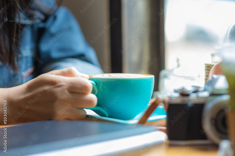Beautiful fashion asian women hold coffee cup sitting in cafe