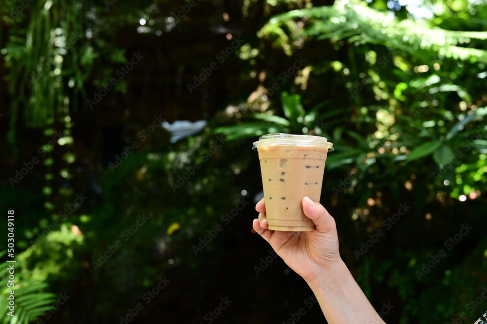Woman hand holding a cup of iced coffee contained in a clear plastic ...