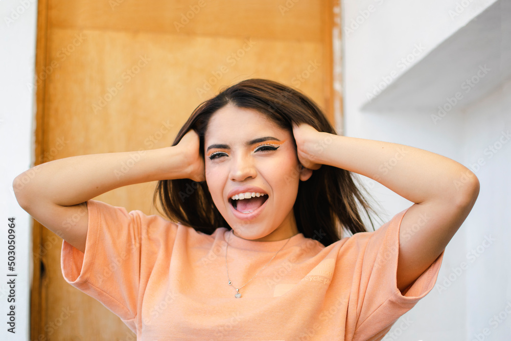 Fototapeta premium Mujer haciendo expresiones con su cara y manos tocando su cabeza