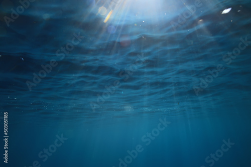 ocean underwater rays of light background, under blue water sunlight © kichigin19