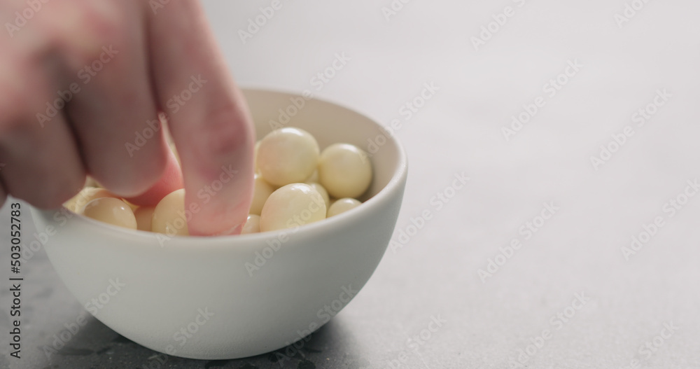 man hand take yogurt covered berries from white bowl with copy space man hand take yogurt covered berries from white bowl with copy space