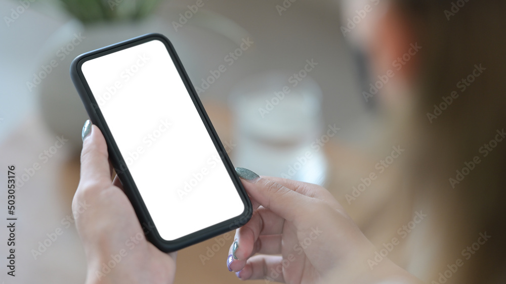 Over shoulder close up view woman using smart phone. Blank screen for text. Over shoulder close up view woman using smart phone. Blank screen for text.