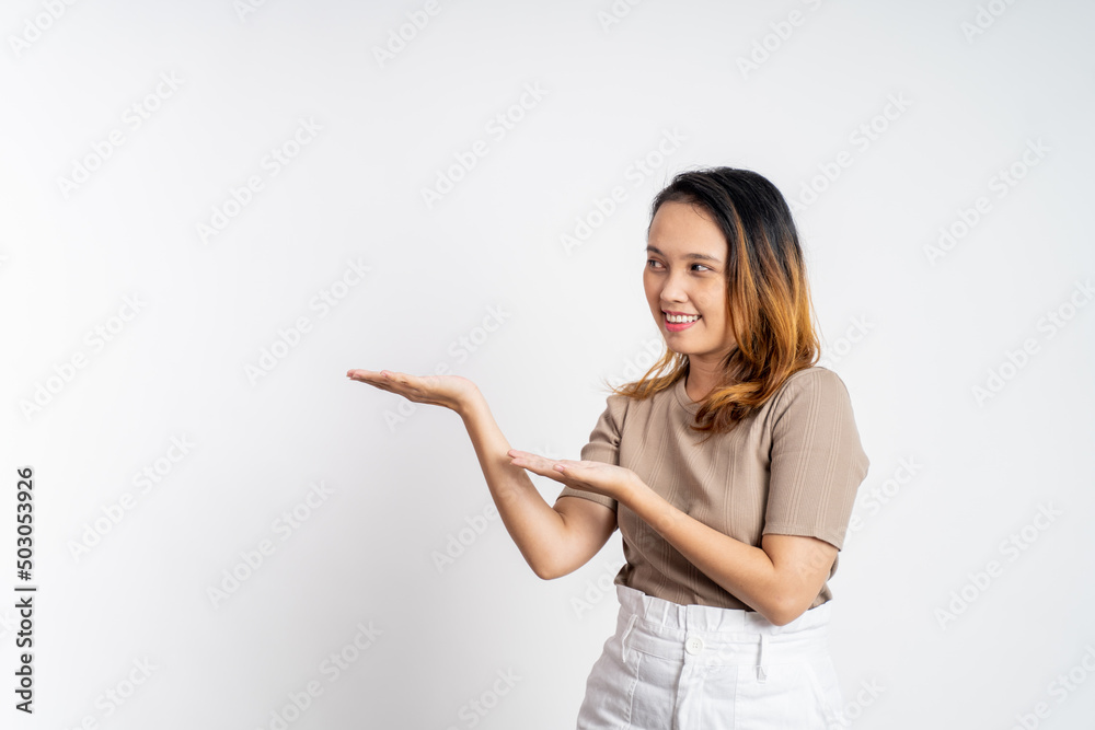 Asian girl with hand gesture presenting something on isolated background Asian girl with hand gesture presenting something on isolated background