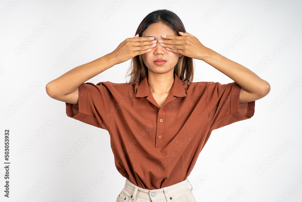 Young asian woman closing eyes with both palms on isolated background Young asian woman closing eyes with both palms on isolated background