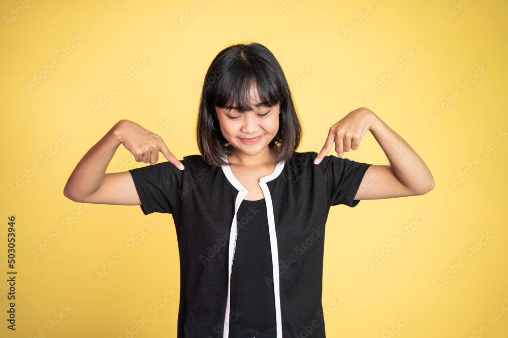 attractive asian woman with finger pointing down hand gesture on isolated background attractive asian woman with finger pointing down hand gesture on isolated background