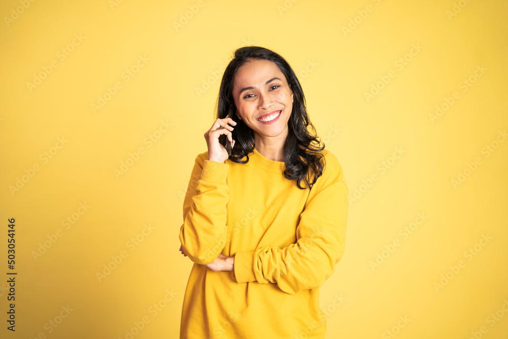 Young asian woman making a call using a cell phone on isolated background Young asian woman making a call using a cell phone on isolated background