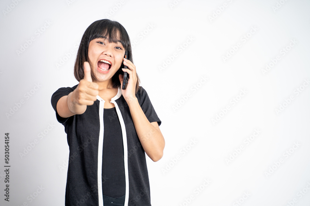 young woman using mobile phone with thumbs up on isolated background young woman using mobile phone with thumbs up on isolated background
