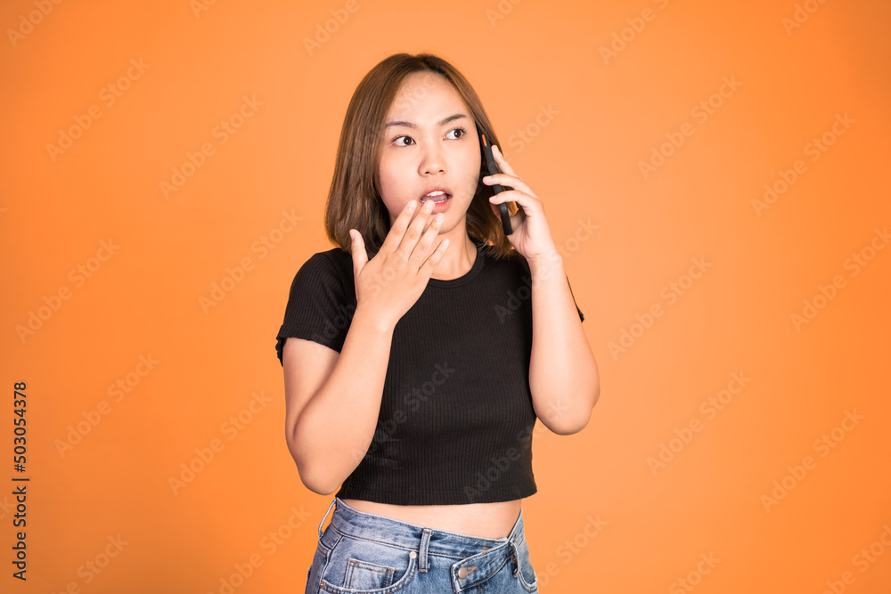 shocked asian woman making a call using a cell phone on isolated background shocked asian woman making a call using a cell phone on isolated background