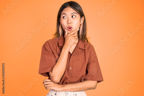 portrait of young asian woman feeling shocked and suprised over isolated background
