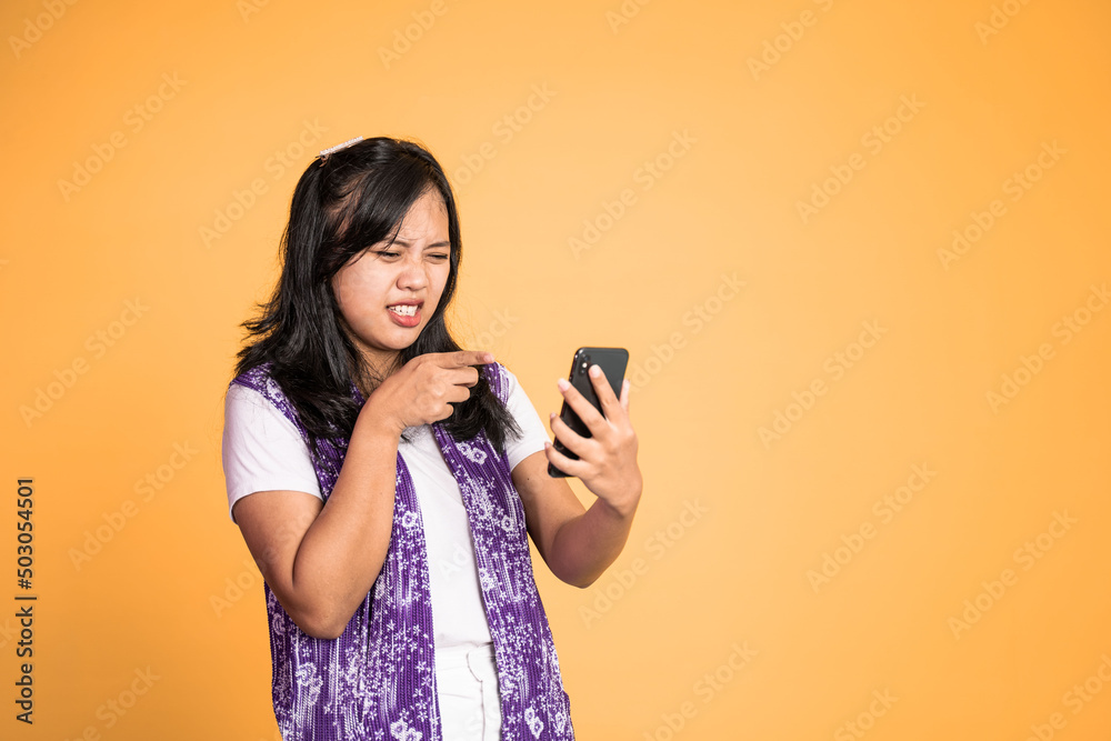mad asian young woman while using mobile phone on isolated background mad asian young woman while using mobile phone on isolated background