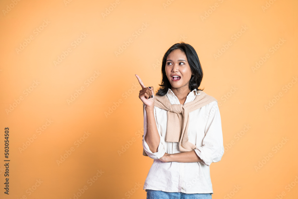 attractive asian woman with finger pointing up hand gesture on isolated background attractive asian woman with finger pointing up hand gesture on isolated background