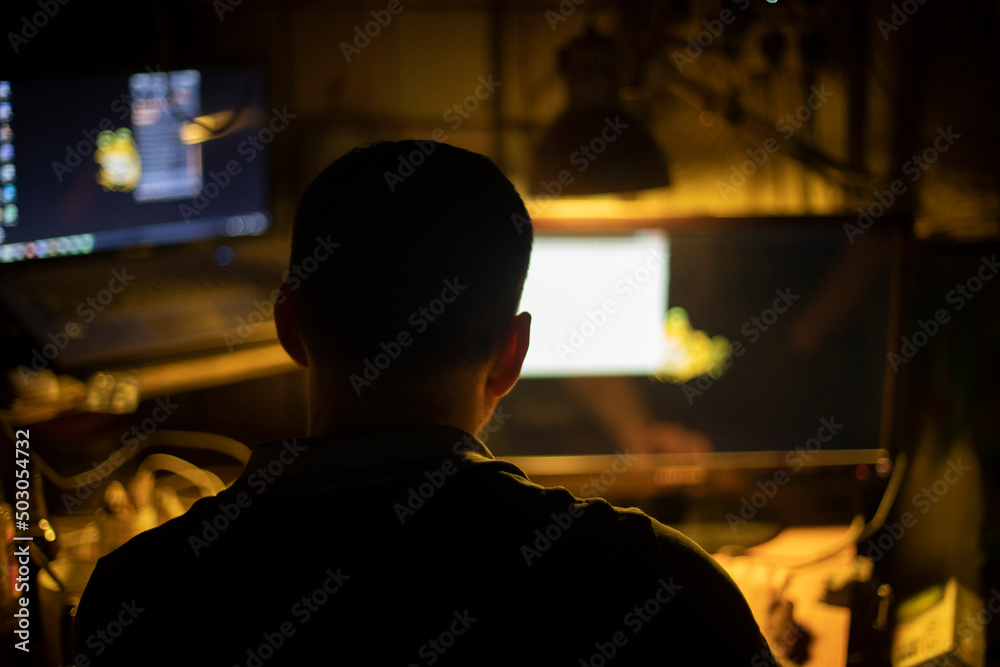 Hacker at computer. Man in dark.