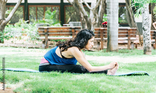 A girl doing stretching yoga, girl doing bharata yoga, young woman doing stretching yoga outdoors photo