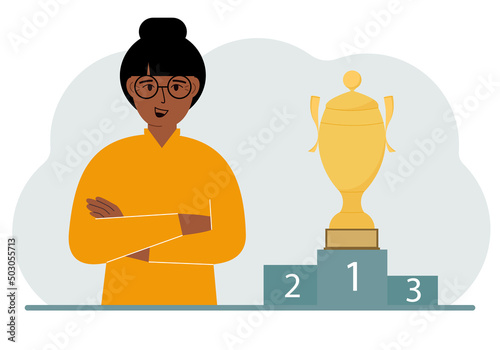A woman next to the pedestal on which the cup for victory and first place.