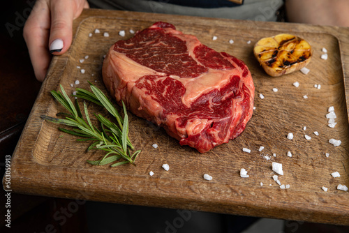 raw meat steak on a wooden board in a premium restaurant 