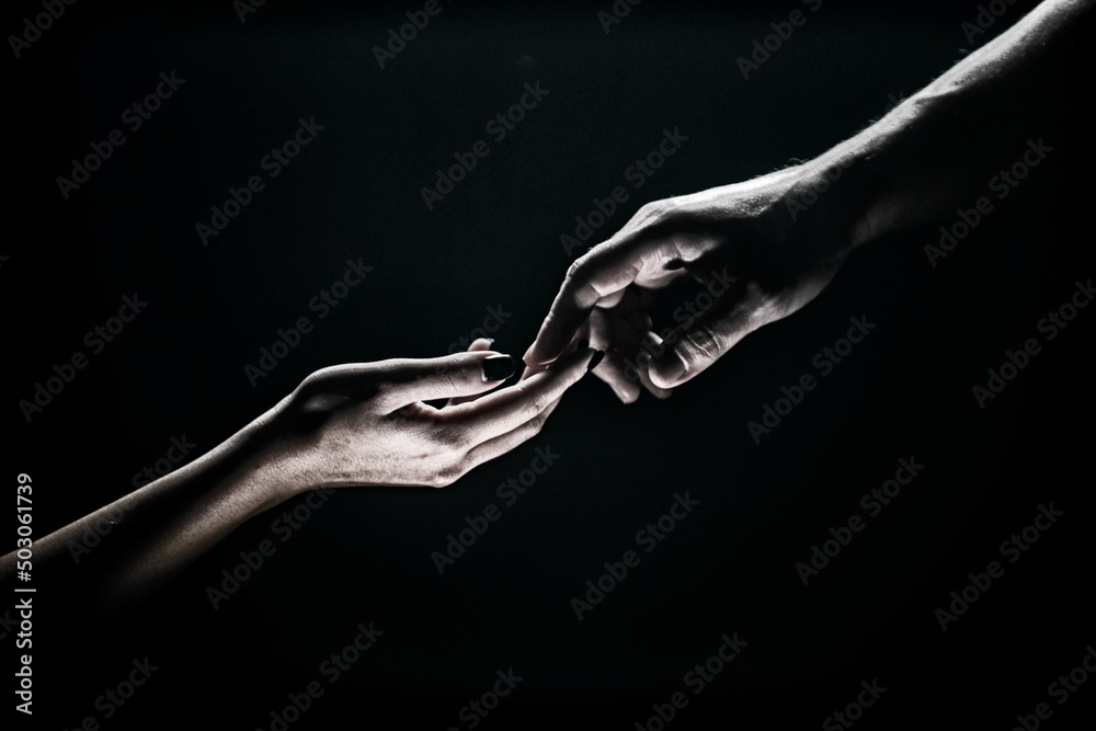 Two hands reaching toward. Tenderness, tendet touch hands in black background. Romantic touch with fingers, love. Hand creation of adam.