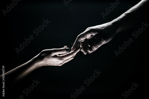 Two hands reaching toward. Tenderness, tendet touch hands in black background. Romantic touch with fingers, love. Hand creation of adam. © Volodymyr