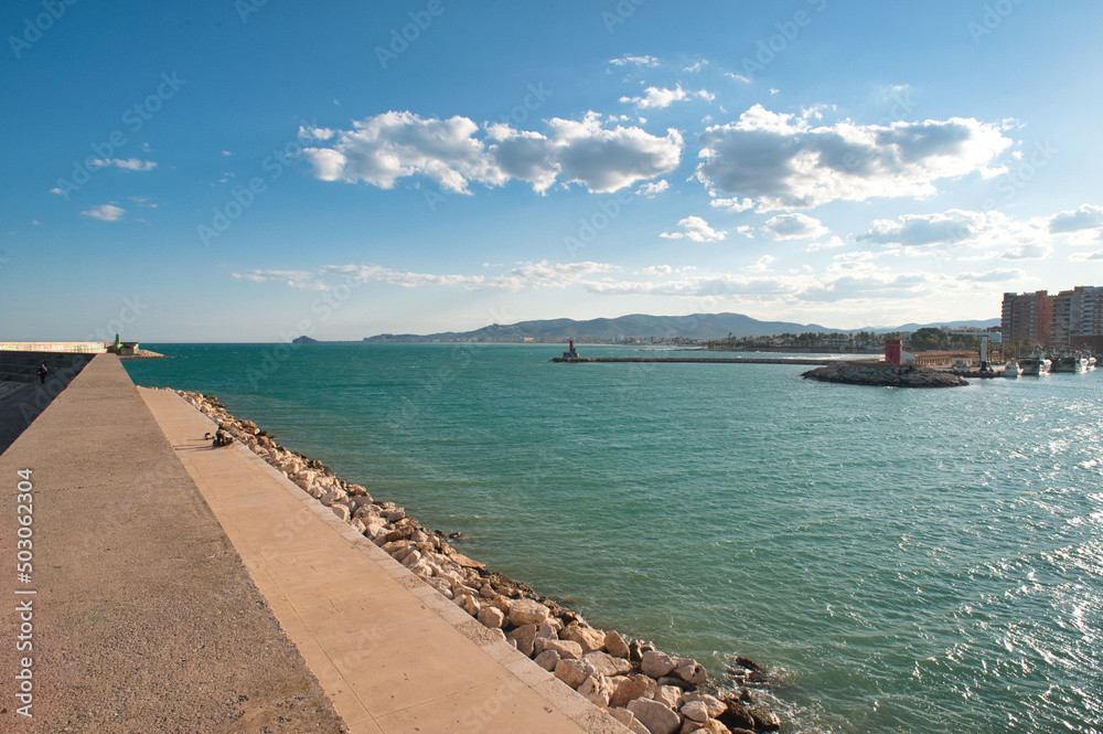 Panoramic view of the entrance to the port of Benicarló. Concrete wall and breakwater of the port. sunset in the harbor