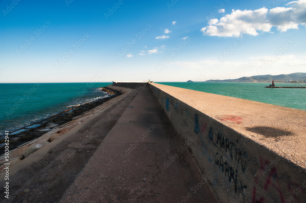 Panoramic view of the entrance to the port of Benicarló. Concrete wall and breakwater of the port. sunset in the harbor Panoramic view of the entrance to the port of Benicarló. Concrete wall and breakwater of the port. sunset in the harbor