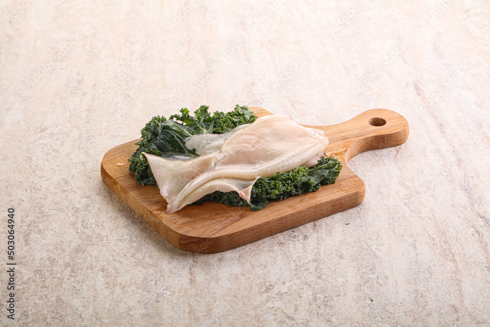 Raw squid over wooden board