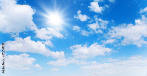 Sunny day background  blue sky with white cumulus clouds and sun
