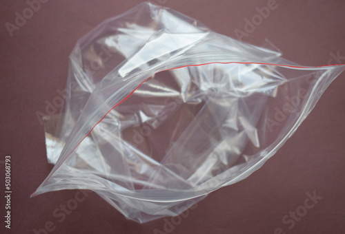Transparent plastic bag with zip clasp on a dark background. The clasp is open.