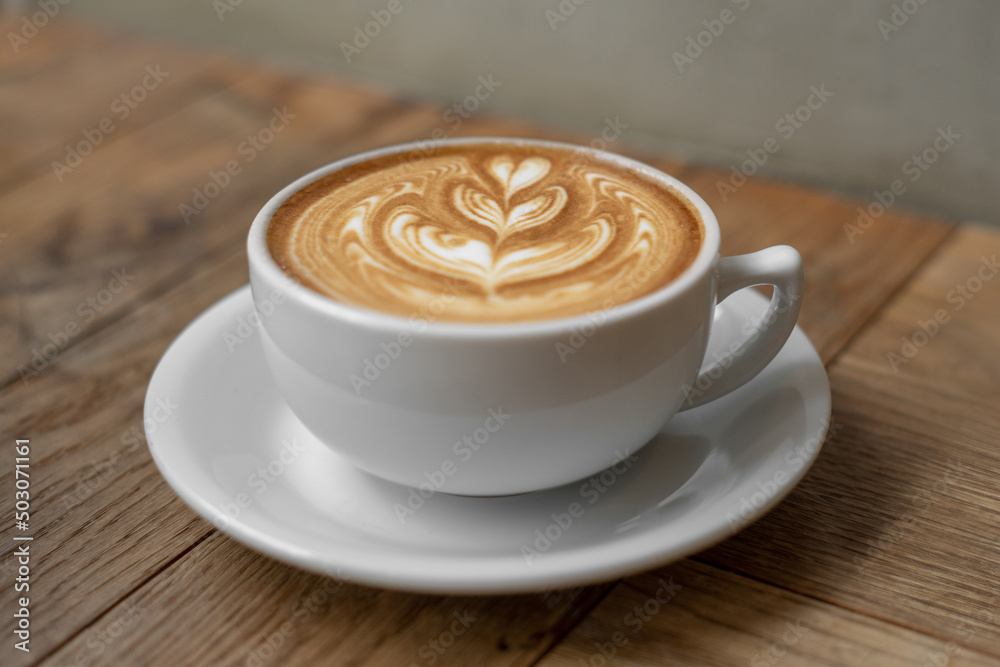 Hot coffee cup with milk late art foam on wood background Hot coffee cup with milk late art foam on wood background