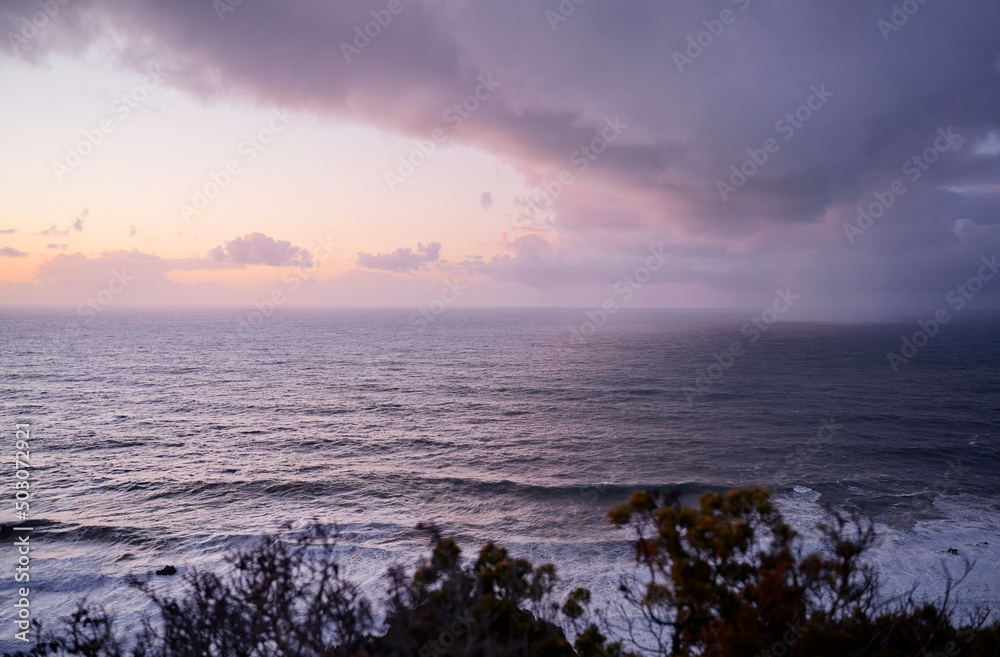 Seascape with cloudy rainy sky and big ocean waves.