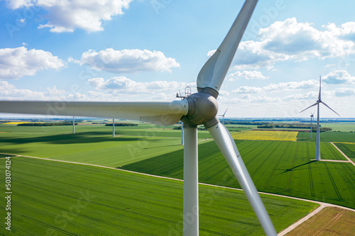 Wind Turbines Windmill Energy Farm. Wind turbines on sunny morning. Windmills wind turbines farm power generators against landscape against blue sky in beautiful nature. Aerial. 