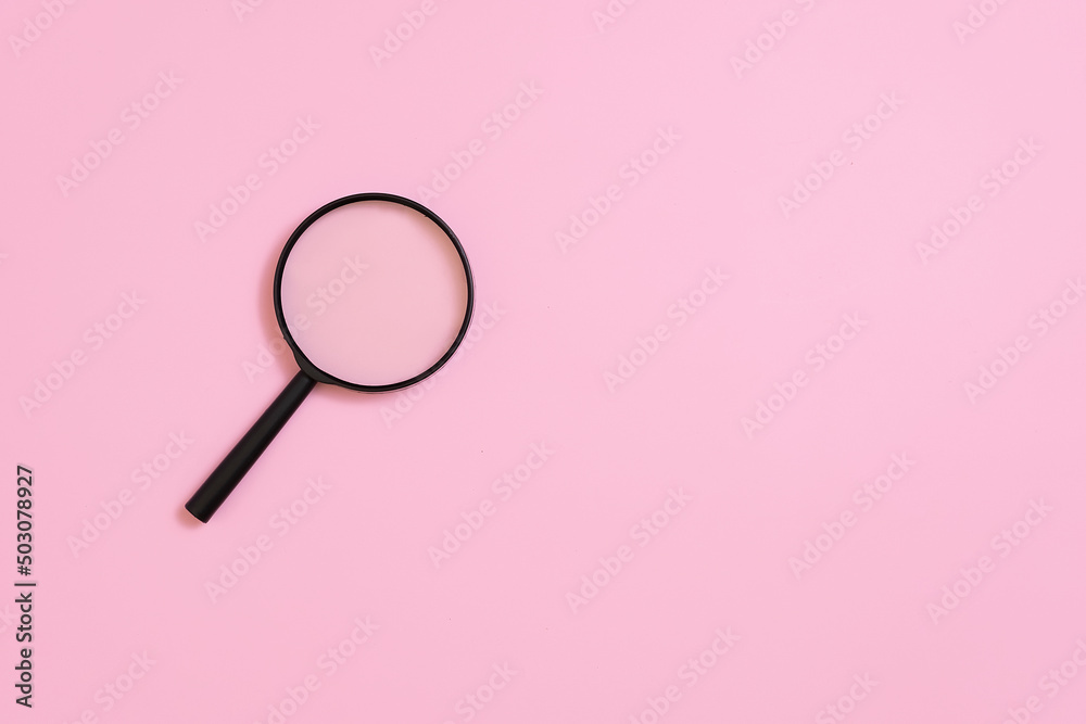 Magnifying glass on a pink background