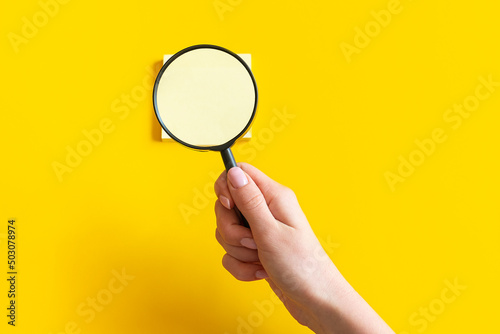 Magnifying glass in hands. Stickers under magnification