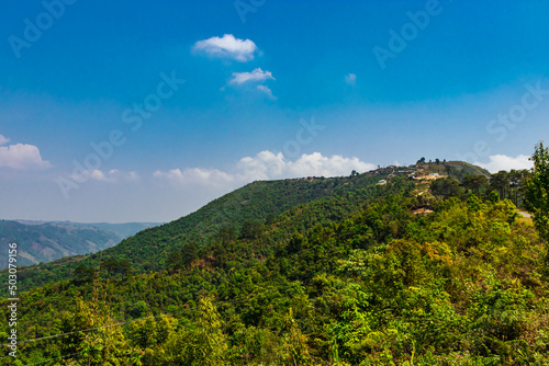 mountain covered with green forests and bright blue sky at morning from flat angle