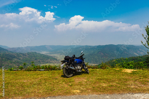 isolated motorcycle parked at mountain top with bright blue sky