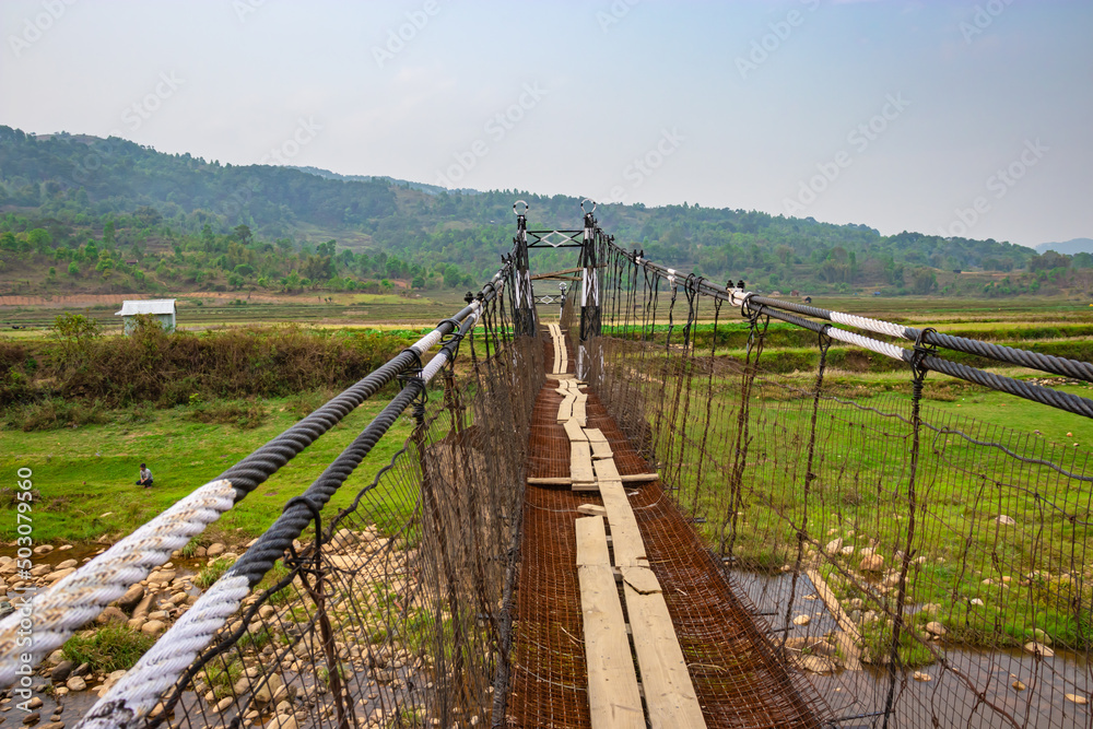 isolated iron suspension bridge old with misty mountain background at morning isolated iron suspension bridge old with misty mountain background at morning