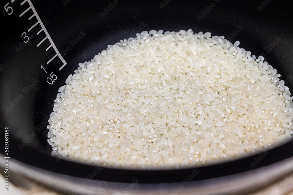 炊飯器の黒い釜の中に白い生米
