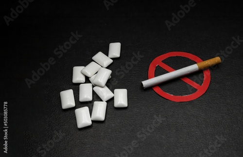 nicotine replacement gum next to a cigarette with the forbidden sign, concept of quitting smoking photo