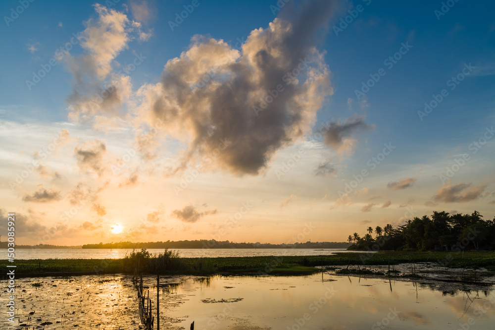 Sunset over a tropical lake with lotus flowers