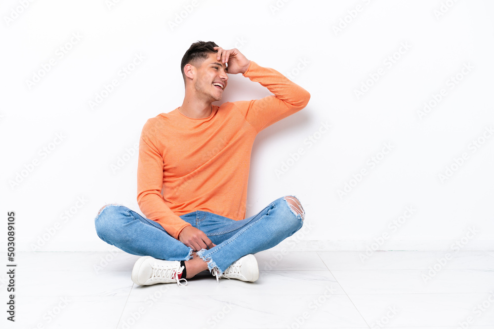 Young man sitting on the floor isolated on white background has realized something and intending the solution Young man sitting on the floor isolated on white background has realized something and intending the solution