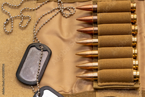 Army identification medallions, bandolier with cartridges, Concept: military special operation, sniper work in war, financing of war, mercenary activities, war crimes.