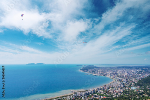 Athlete paragliding against the backdrop of a cloudy sky over the city on a summer day. Albania © netdrimeny