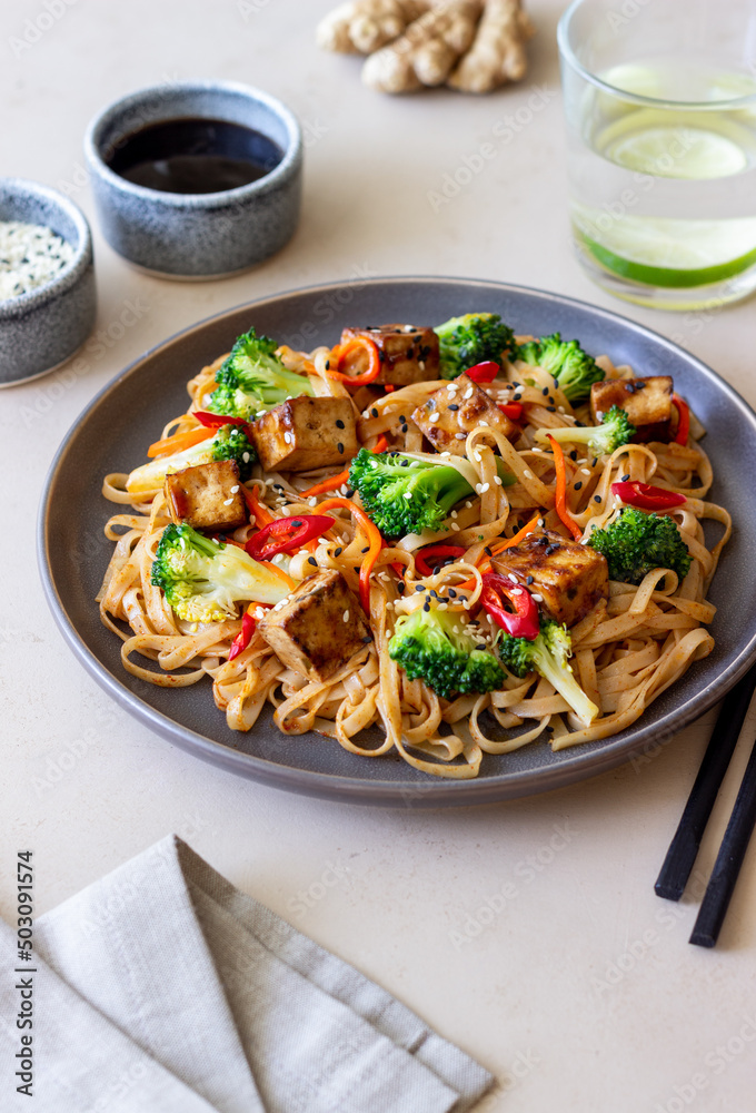 Udon noodles with tofu, broccoli, carrots, pepper and sesame. Healthy eating. Vegetarian food. Asian food. Udon noodles with tofu, broccoli, carrots, pepper and sesame. Healthy eating. Vegetarian food. Asian food.