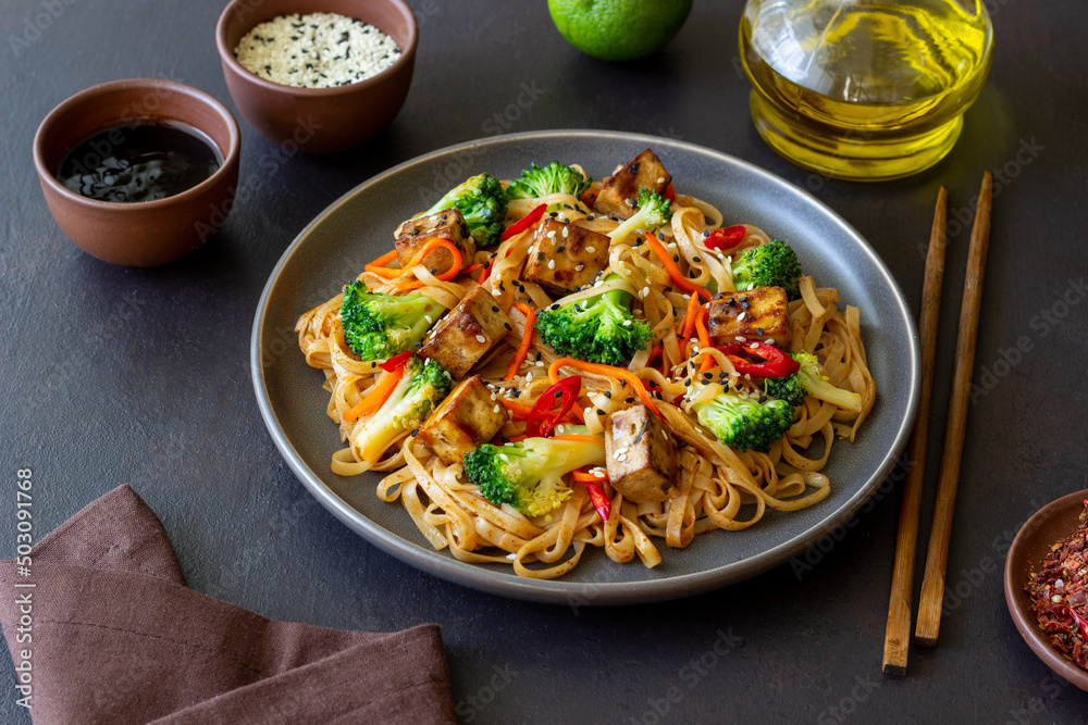 Udon noodles with tofu, broccoli, carrots, pepper and sesame. Healthy eating. Vegetarian food. Asian food. Udon noodles with tofu, broccoli, carrots, pepper and sesame. Healthy eating. Vegetarian food. Asian food.