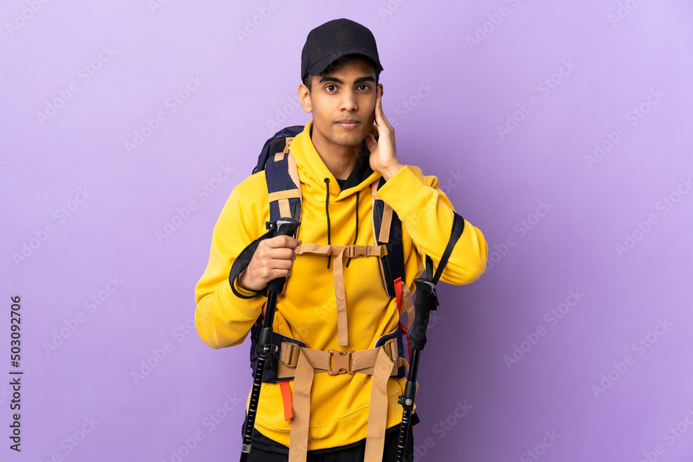 African American man with backpack and trekking poles over isolated background frustrated and covering ears African American man with backpack and trekking poles over isolated background frustrated and covering ears