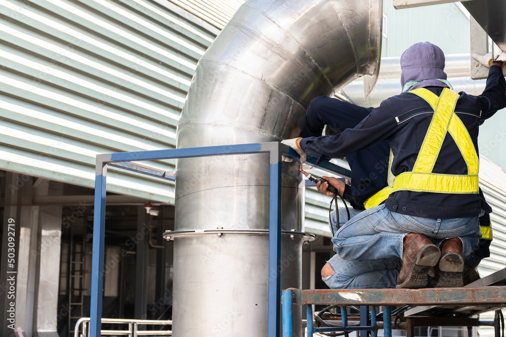 Welder wearing personal protective equipment (PPE) gas pipe repair