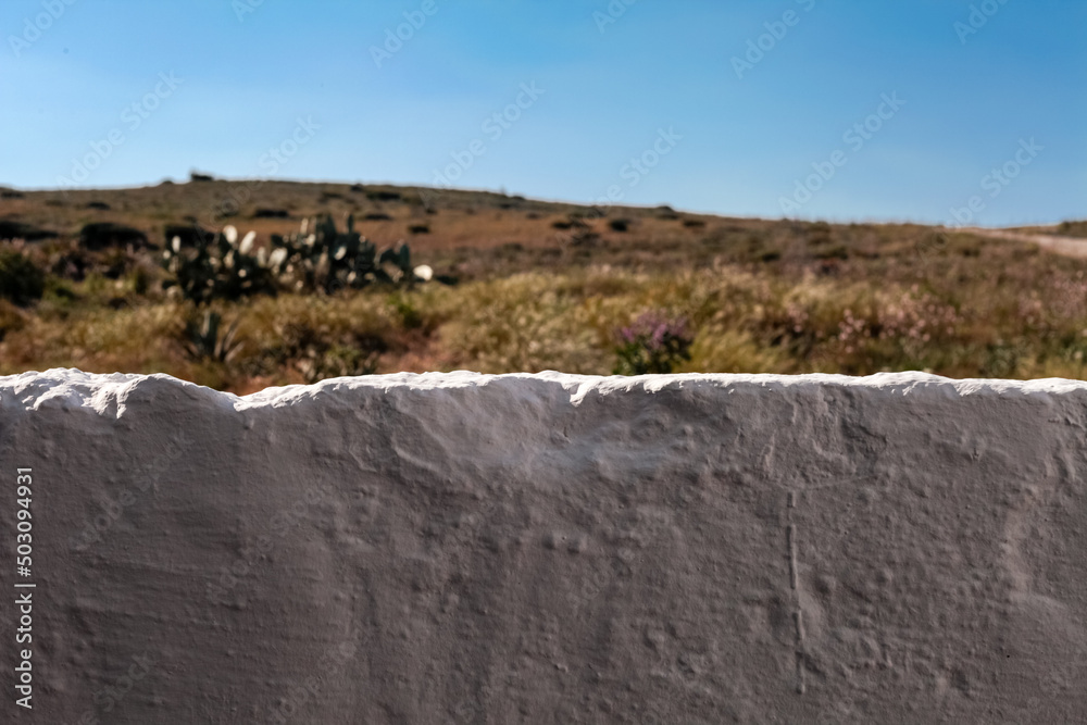 Subjective view of a white stone fence from a house