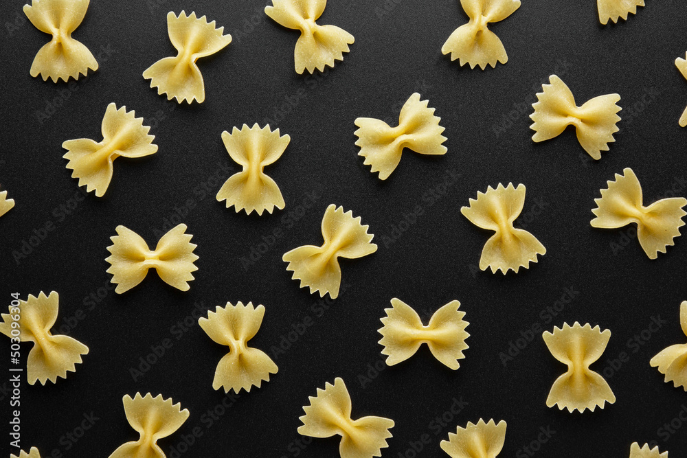 Raw pasta farfalle pattern on black background. Raw pasta farfalle pattern on black background.