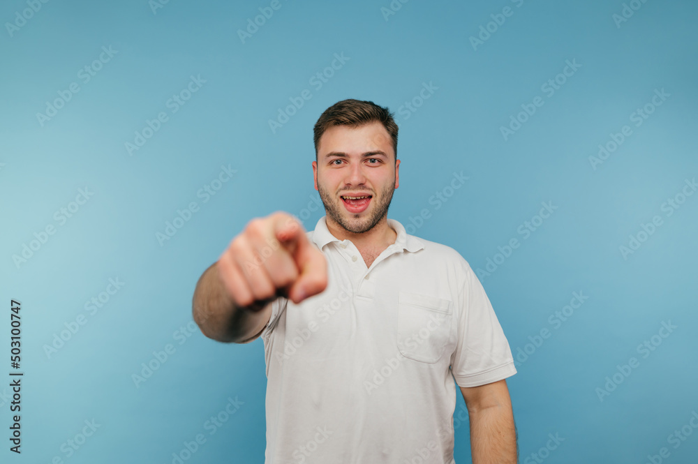 Joyful man with a smile on his face stands on a blue background and looks at the camera with a smile on his face. Joyful man with a smile on his face stands on a blue background and looks at the camera with a smile on his face.
