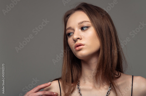 Girl with loose hair having and posing on grey background.