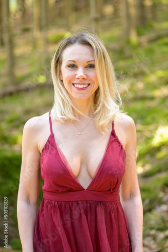 Smiling blond woman wearing magenta dress. © michaelheim