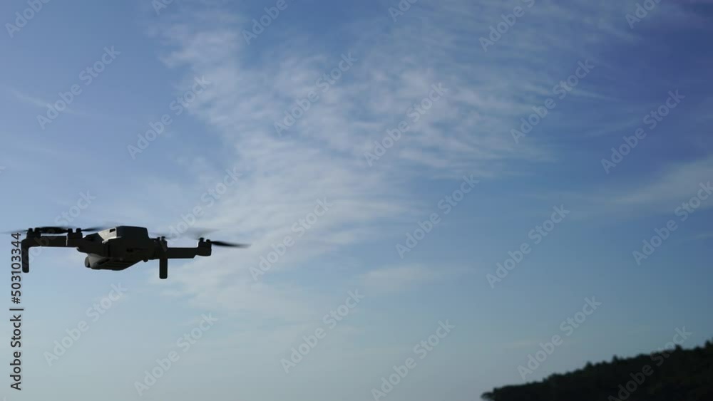 Flying drone in the air against the background of a blue sky with a slight cloudiness. High quality 4k footage Flying drone in the air against the background of a blue sky with a slight cloudiness. High quality 4k footage
